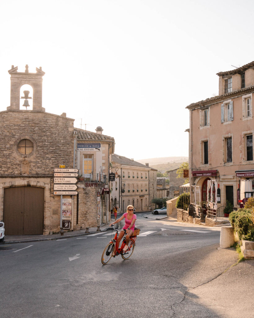 woman riding bike through the streets of Gordes Village France