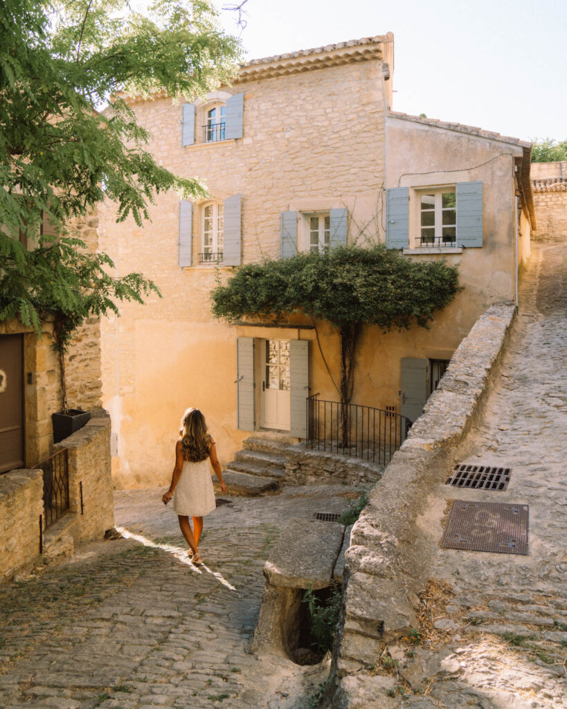 adriana maria walking through the streets of Gordes village in Provence France 