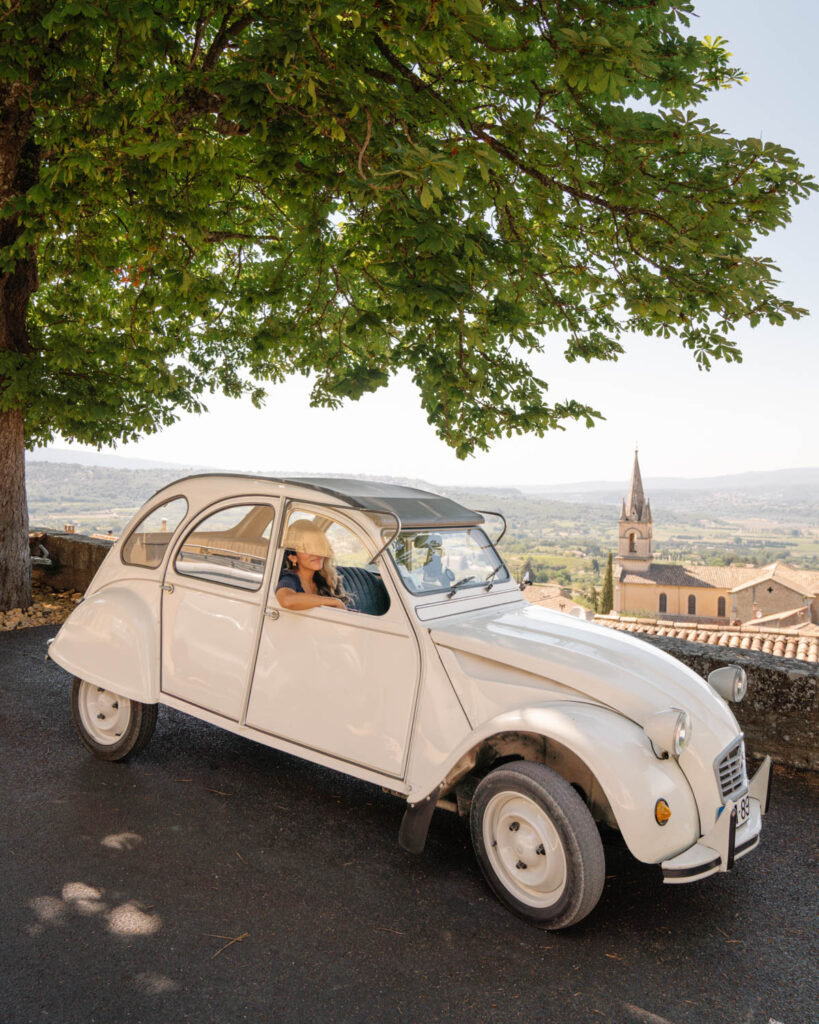 girl driving vintage citroen 2cv in the countryside of provence france