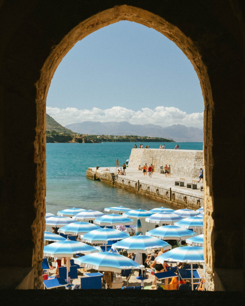 blue and white umbrellas at the beach in Cefalù, Sicily