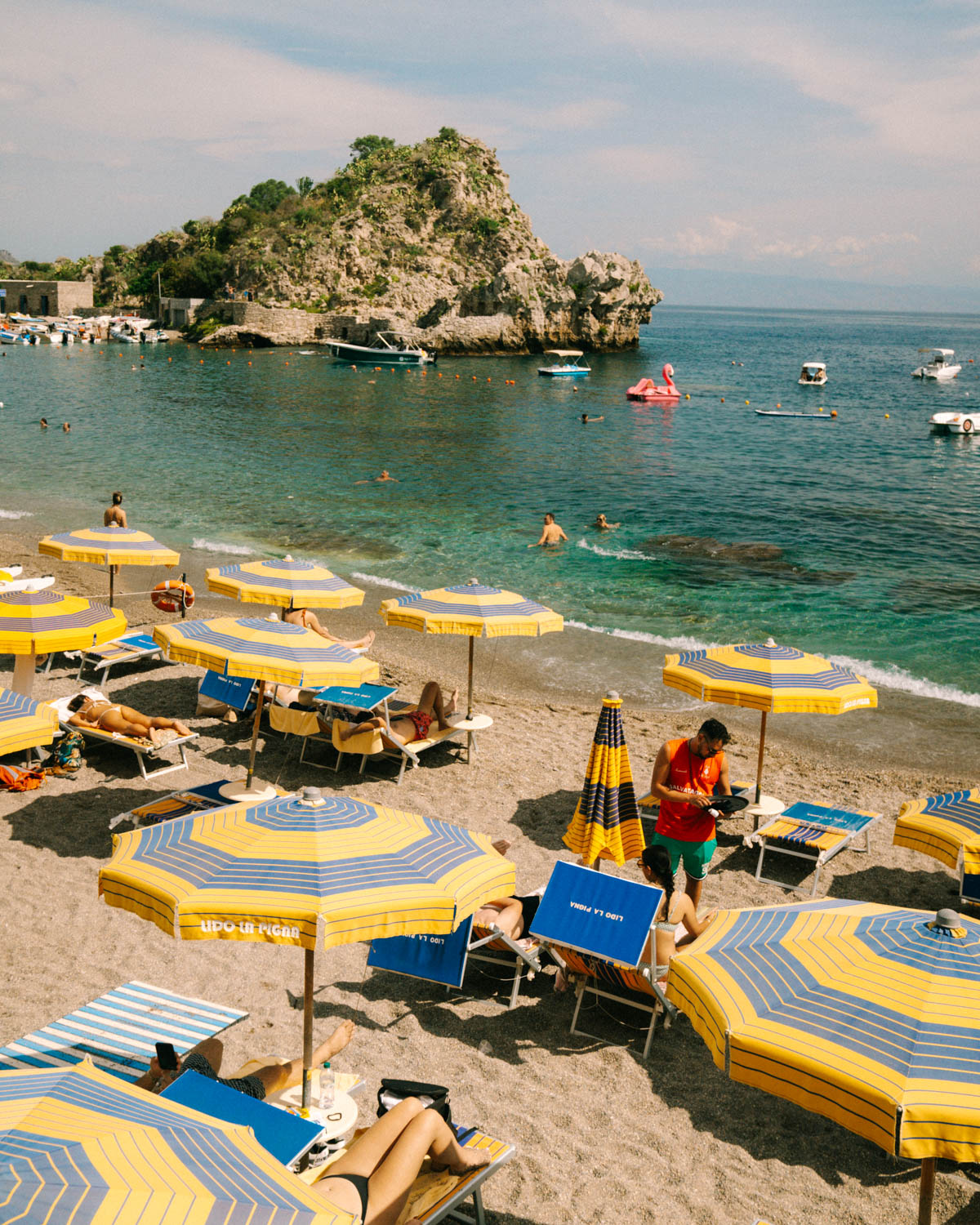 Mazzarò Beach with yellow umbrellas and turquoise water.