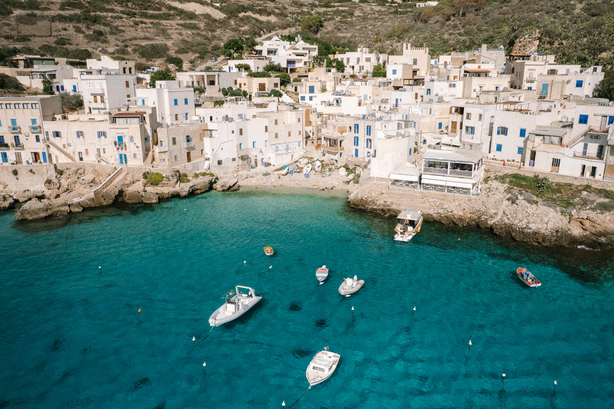white washed fishing village houses set by blue Mediterranean sea on Levanzo island off the coast of Sicily Italy