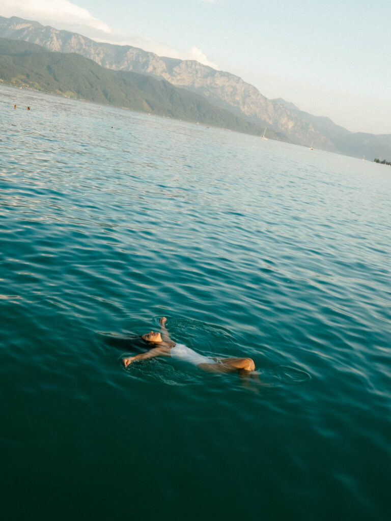 a woman swiming in Attersee lake austria in the summer time 